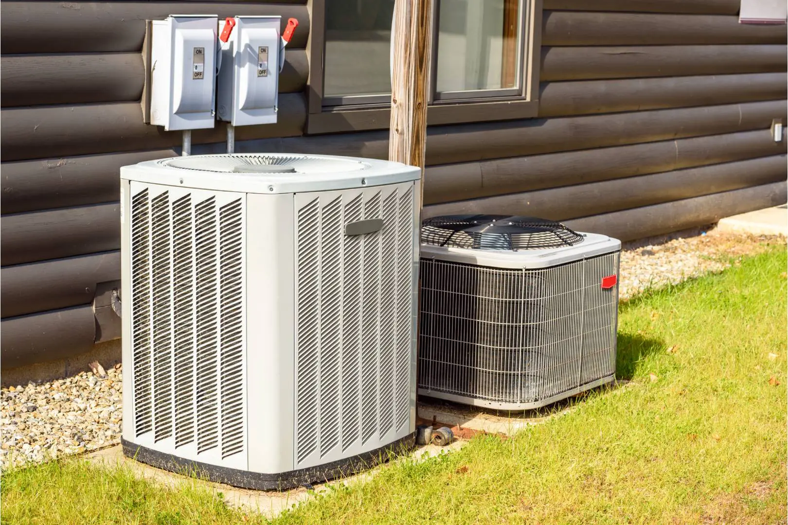 A couple of air conditioners sitting outside of a house.