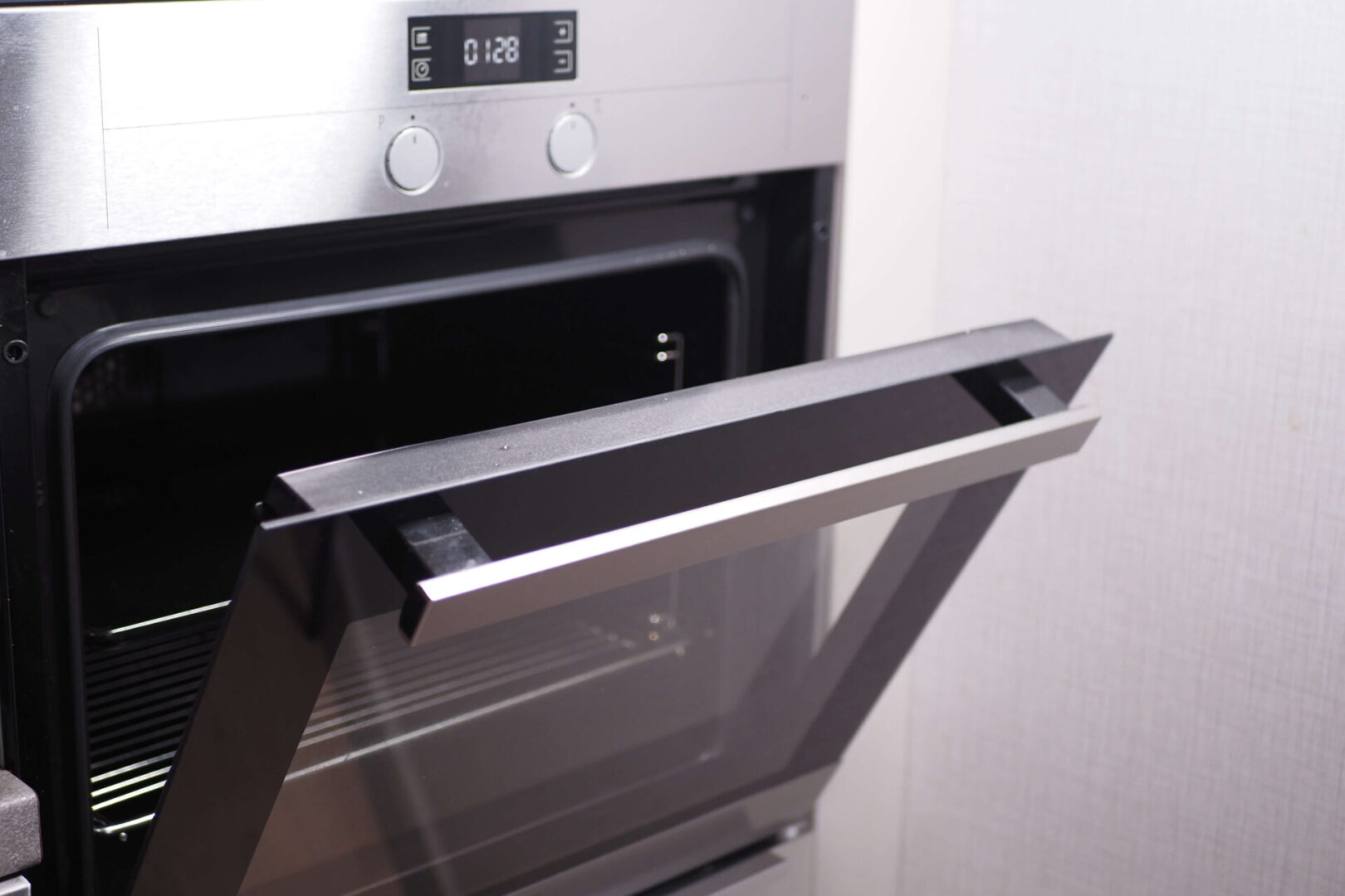 A close up of an oven door with the handle open